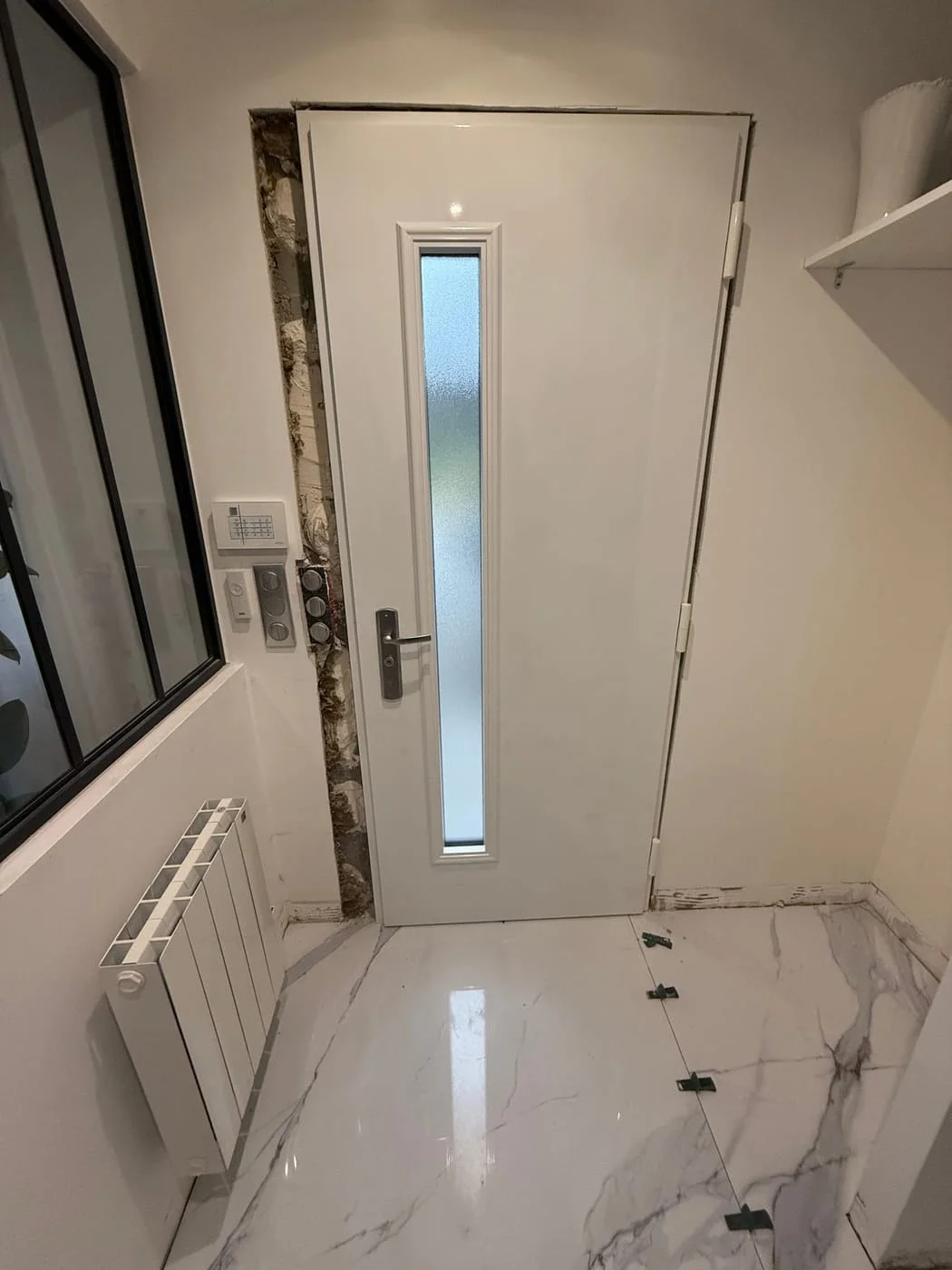 Porte intérieure blanche installée sur sol en marbre, intervention Serrurerie Legrand